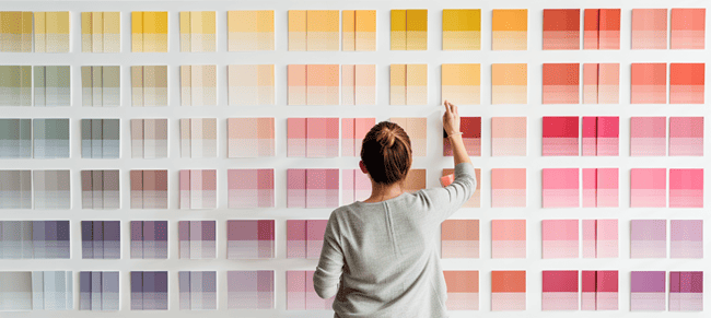 A Lady Taping Color Swatches to the Wall